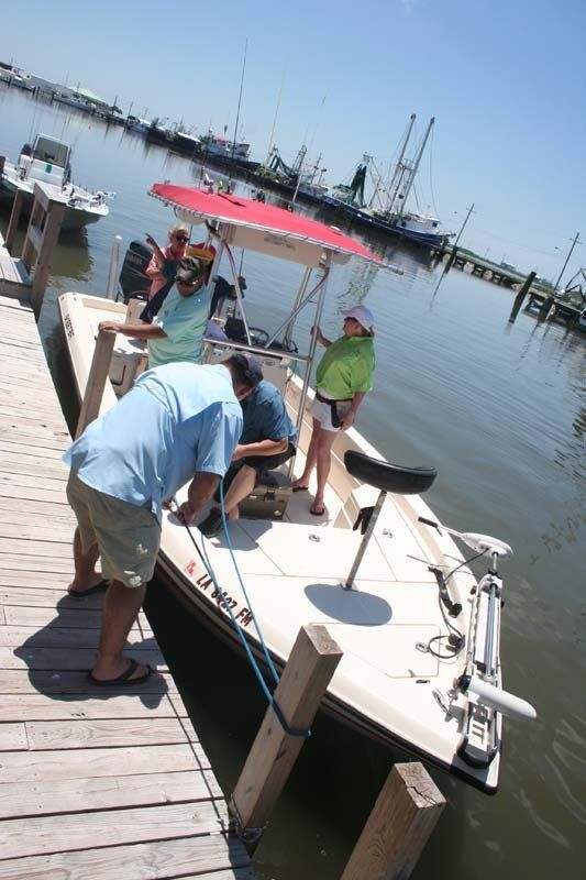 A boat with a red canopy is docked at a dock