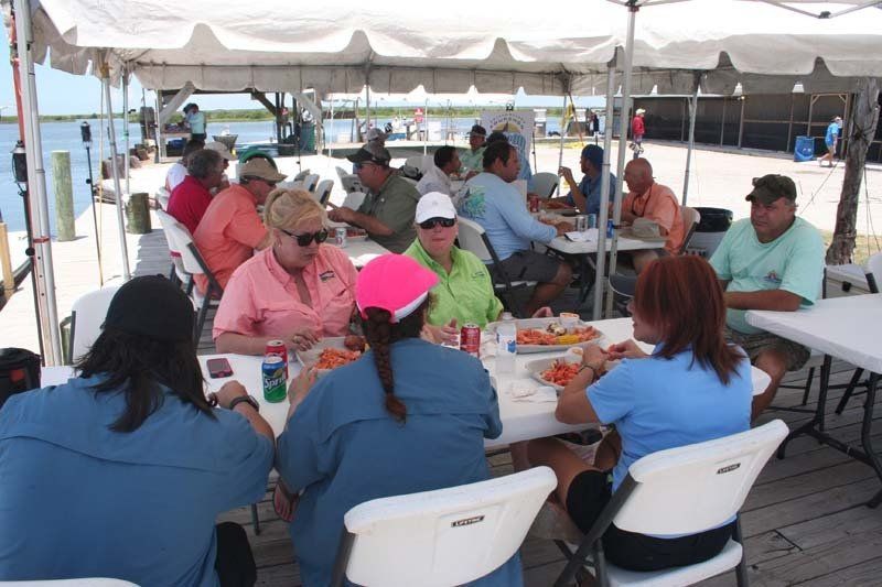 A group of people are sitting at tables under a tent