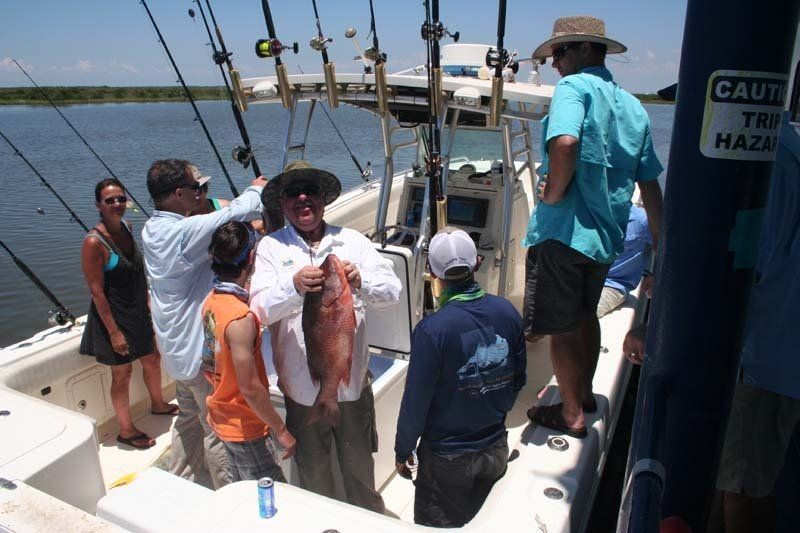 A group of people standing on a boat with a sign that says caution 1 mile haze