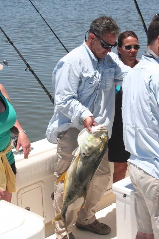A man is holding a large fish on a boat