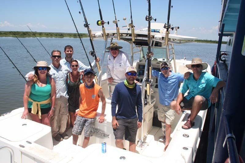A group of people standing on a boat with fishing rods