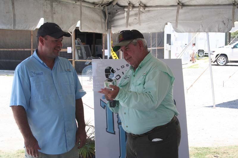 Two men are standing under a tent talking to each other