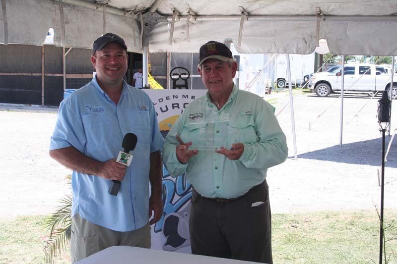 Two men are standing under a tent holding microphones