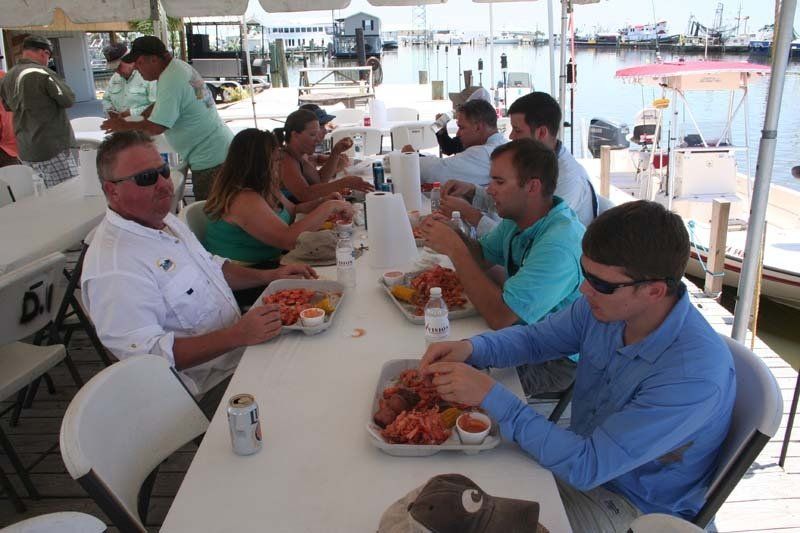 A group of people are sitting at a long table eating food