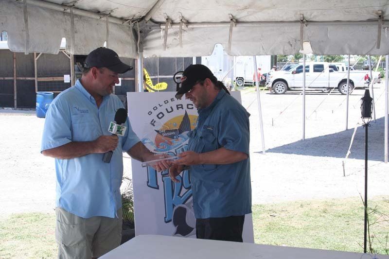 Two men are standing under a tent talking to each other