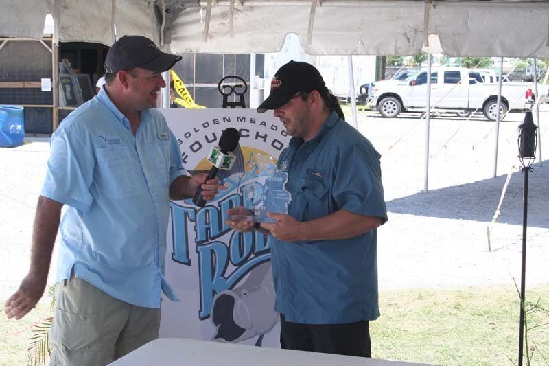 Two men are standing under a tent talking to each other