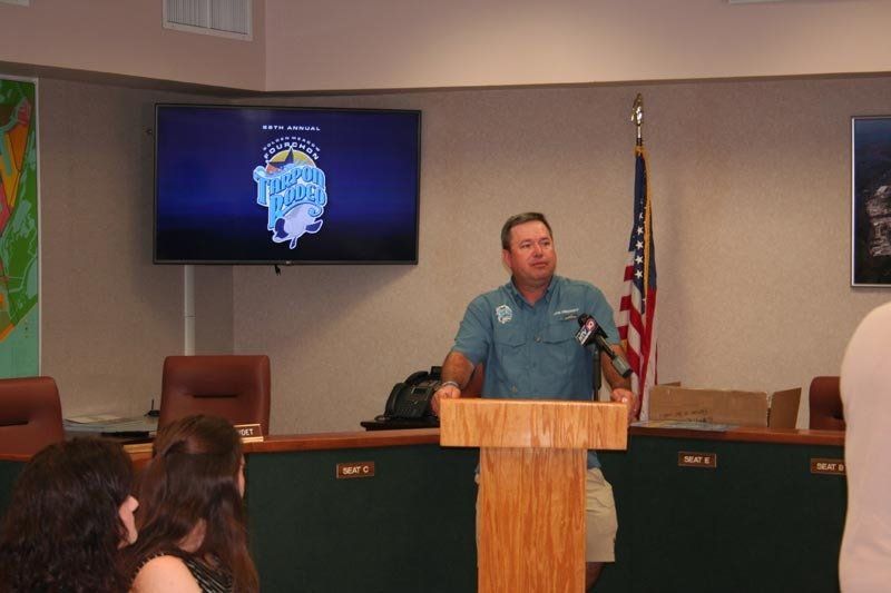 A man is standing at a podium in front of a group of people.