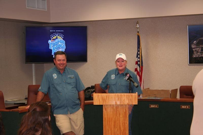 Two men standing behind a podium with a screen behind them that says rapid river