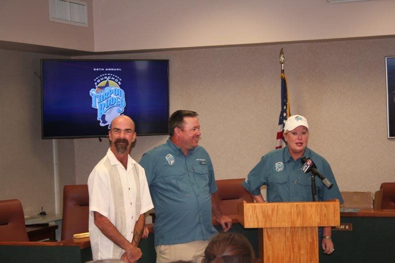 Three men are standing at a podium in front of a screen that says blue moon
