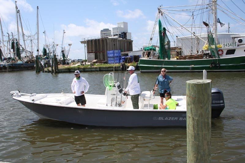A group of people are standing on a boat in the water.