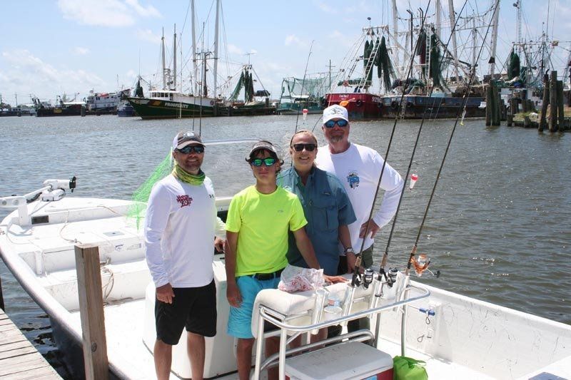 A group of men are standing on a boat in the water.