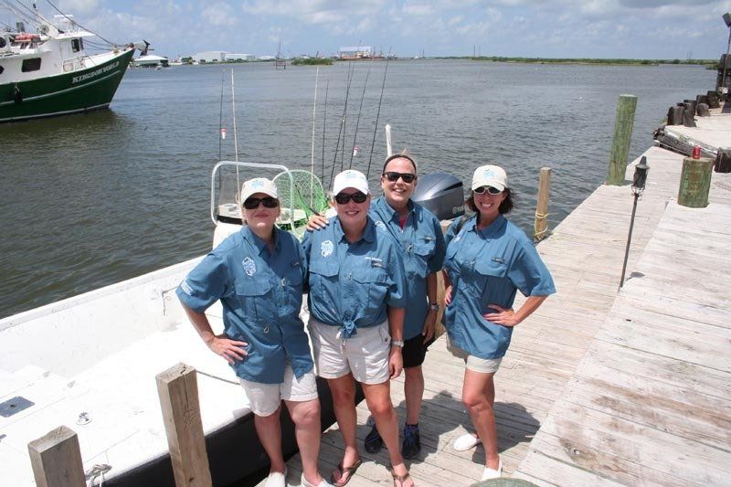 A group of people standing on a dock next to a boat