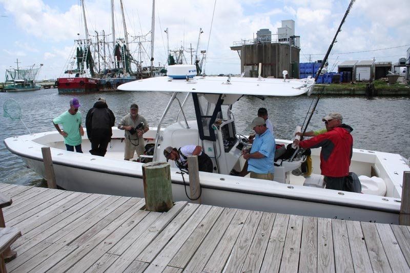 A group of men are fishing on a boat in the water.