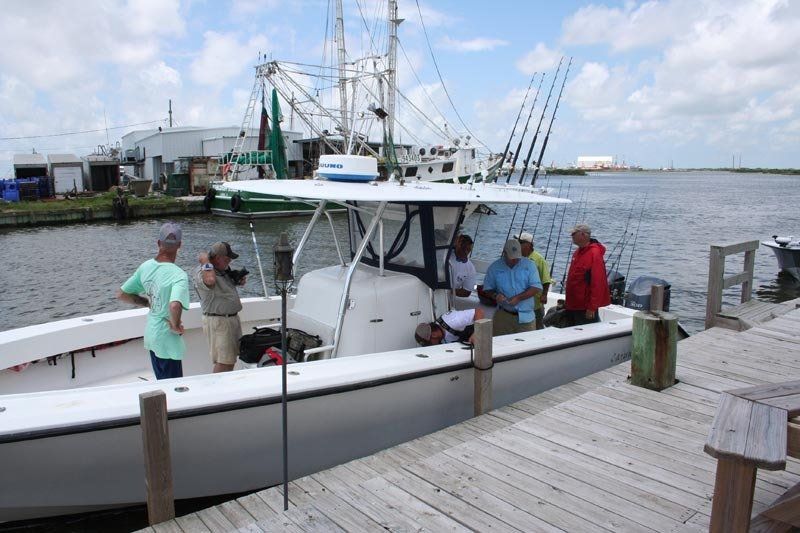 A group of people standing on a dock next to a boat
