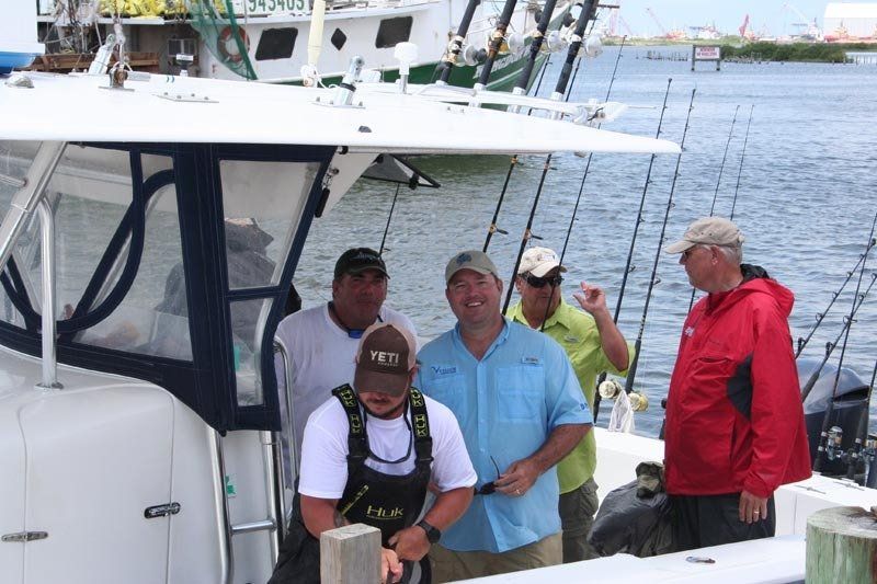 A group of men are standing on a boat in the water