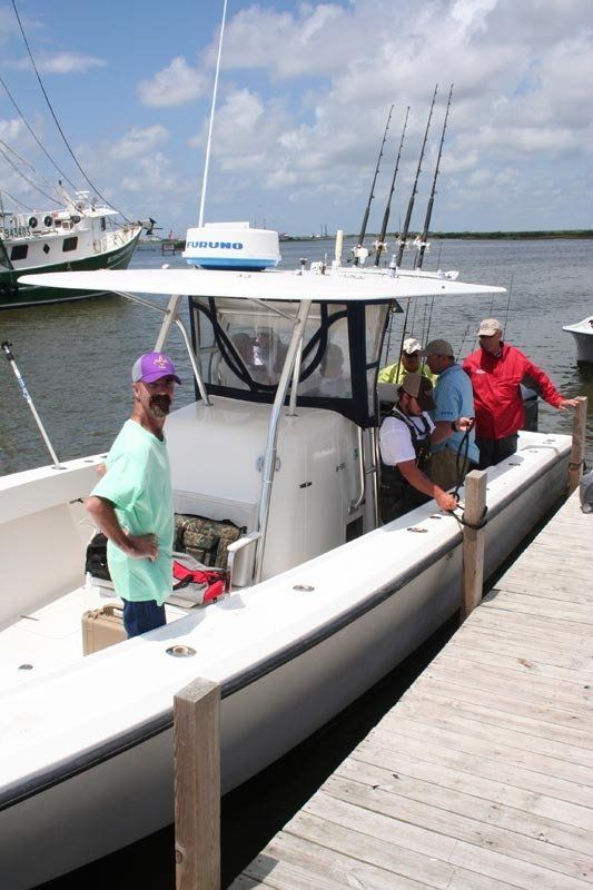 A group of men are standing on a dock next to a boat