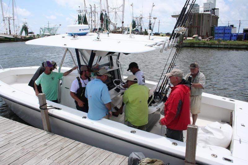 A group of men are standing on a boat in the water