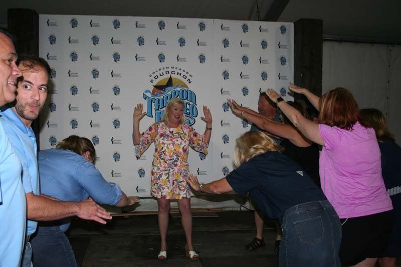 A group of people are dancing in front of a sign that says comedy