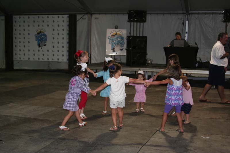 A group of little girls are dancing in a circle