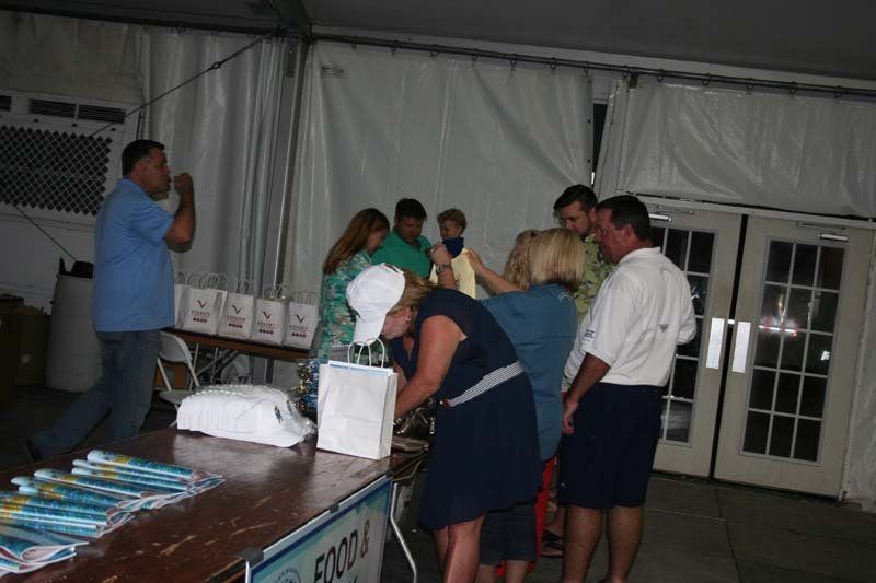 A group of people are standing around a table in a tent.
