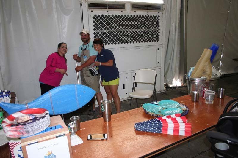A group of people are standing around a table.