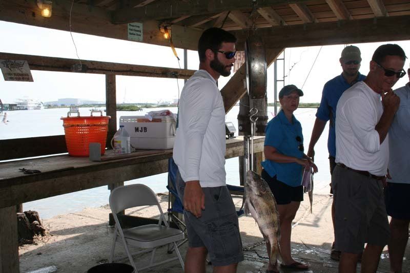 A group of people are standing around a fishing dock