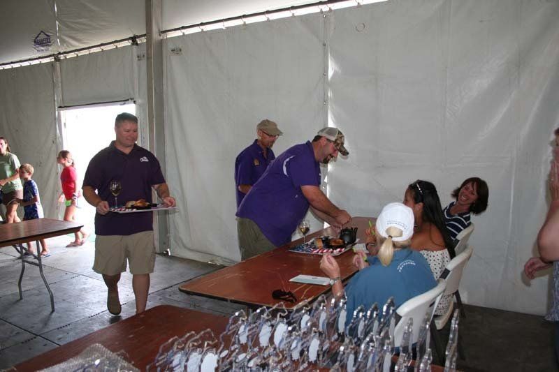 A man in a purple shirt is serving food to a group of people