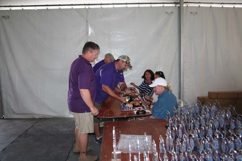 A group of people standing around a table with trophies on it