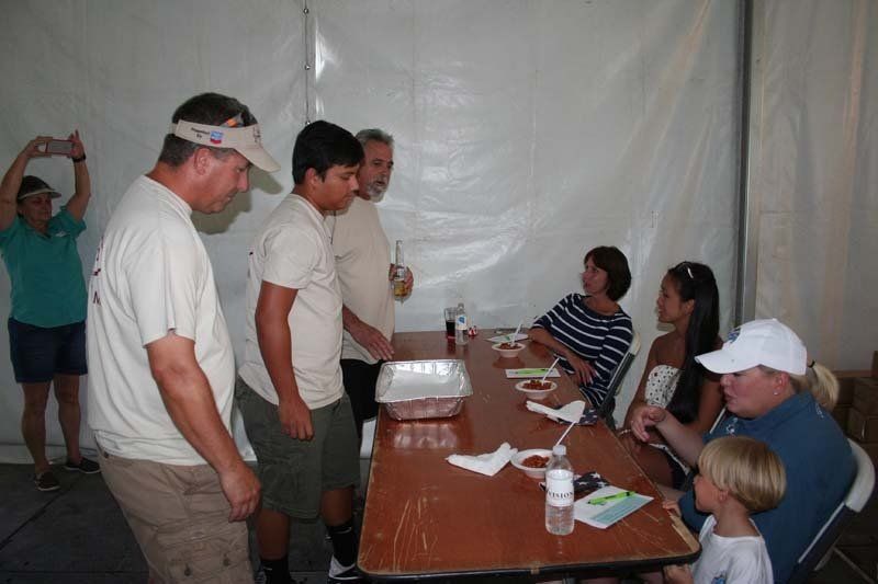 A group of people standing around a table in a tent