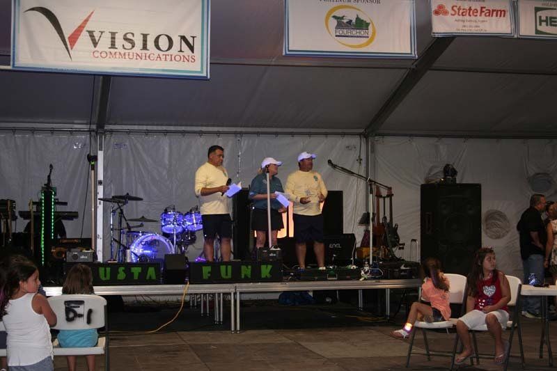 A group of people standing on a stage under a sign that says vision communications