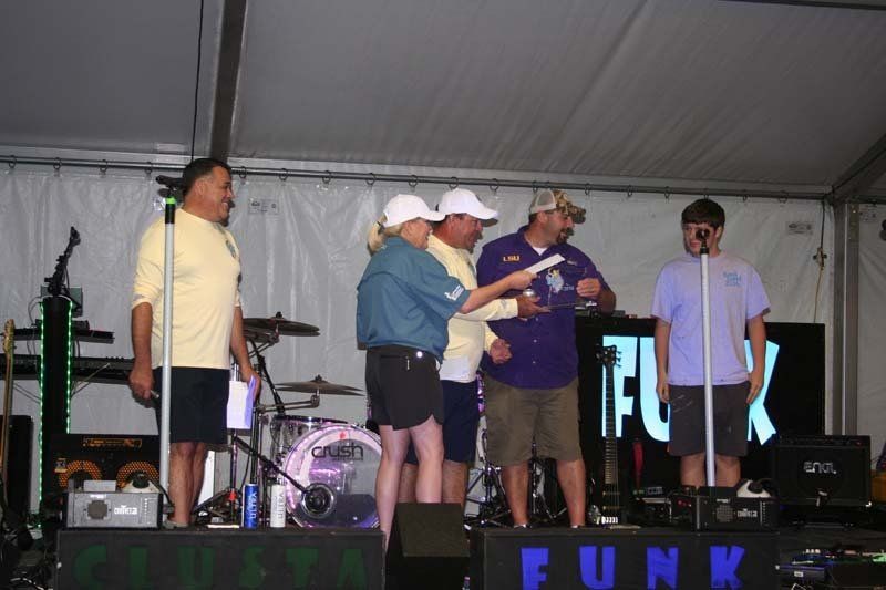 A group of people standing on a stage in front of a sign that says funk