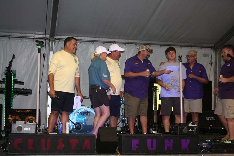 A group of people standing on a stage with a sign that says clusta funk