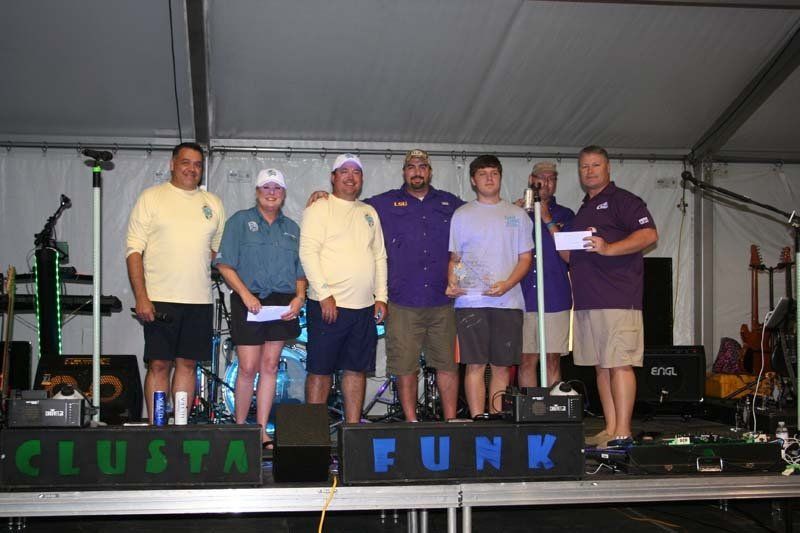 A group of people standing on a stage with a sign that says funk