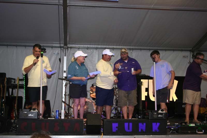 A group of people standing on a stage in front of a sign that says funk