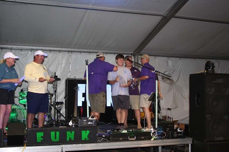 A group of people standing on a stage in front of a sign that says funk
