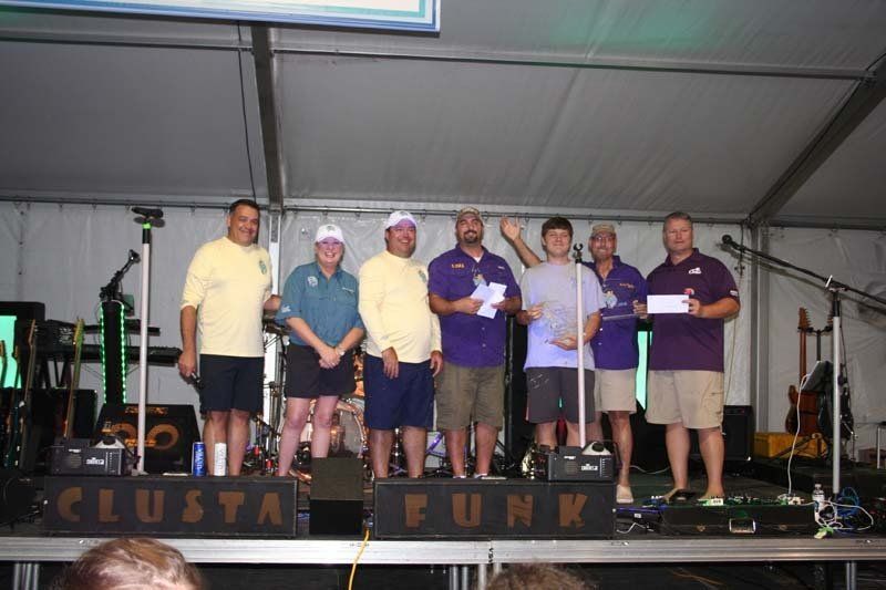 A group of men standing on a stage in front of a sign that says cluster funk