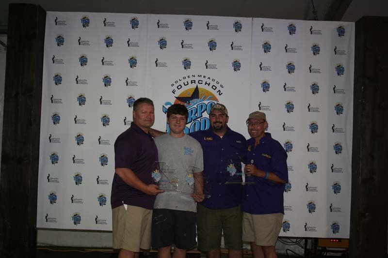 A group of men are posing for a picture in front of a wall that says fourhands