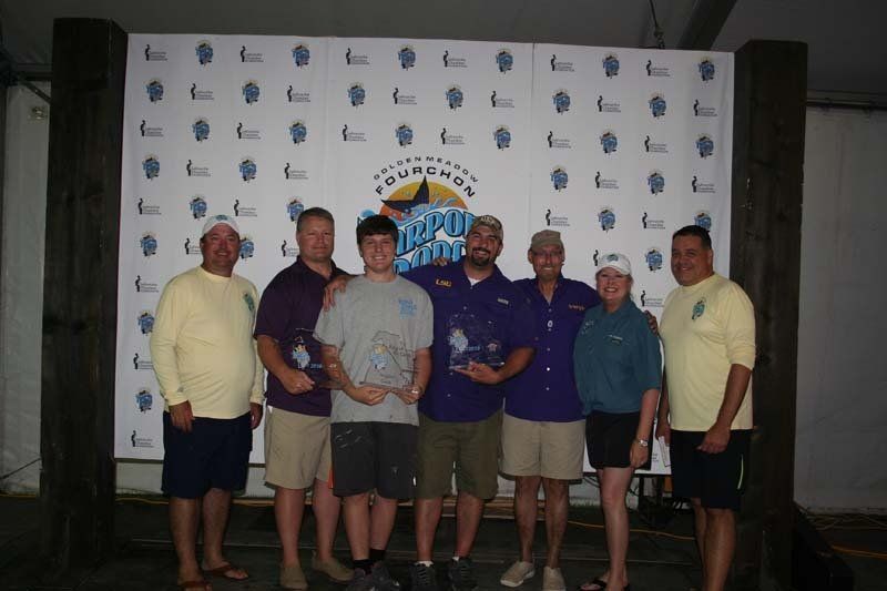A group of men are posing for a picture in front of a wall that says ' johnson ' on it