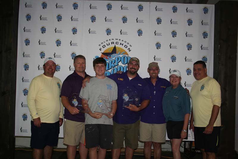 A group of people are posing for a picture in front of a wall that says gulf coast