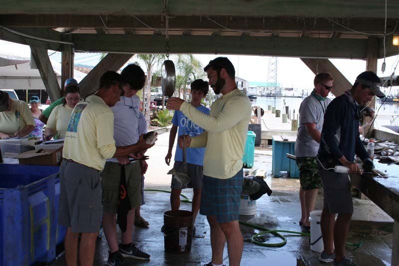 A group of men are standing under a covered area looking at something
