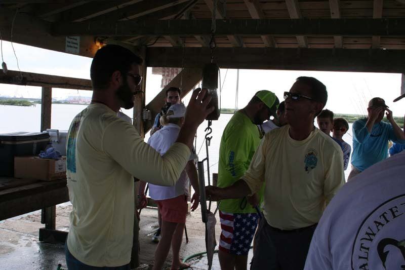 A man in a yellow shirt is taking a picture of a group of people