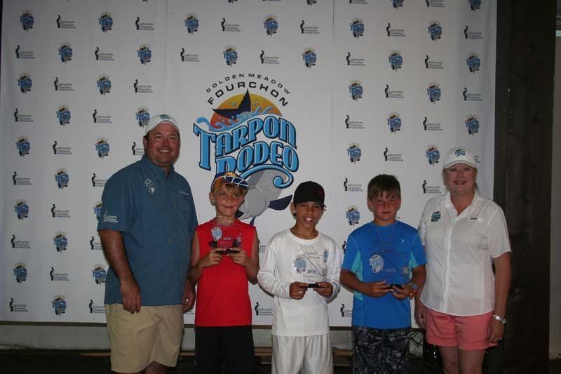 A group of people standing in front of a wall that says happy rodeo