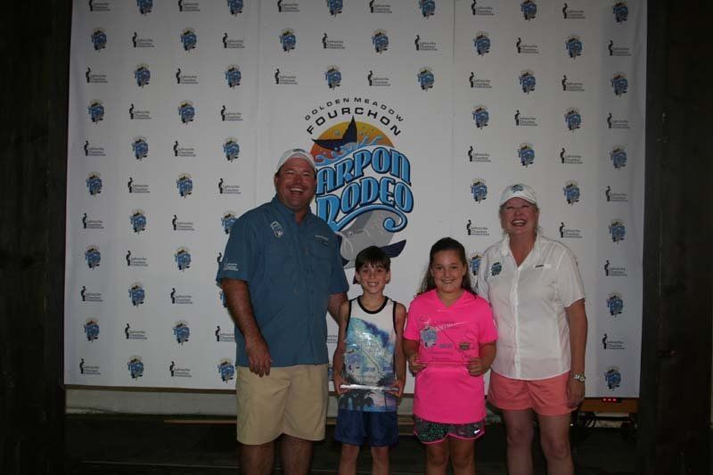 A group of people standing in front of a wall with a dolphin on it.