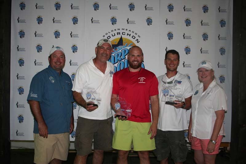 A group of people are posing for a picture in front of a wall that says squadron