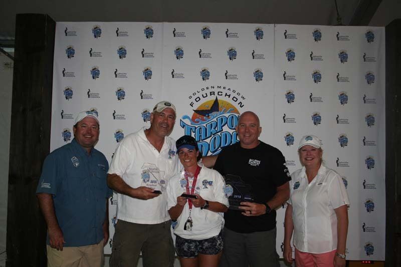 A group of people are posing for a picture in front of a wall that says tampa bay