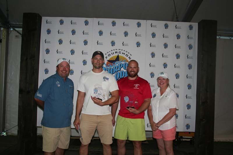 A group of people are posing for a picture in front of a wall that says southern tide.