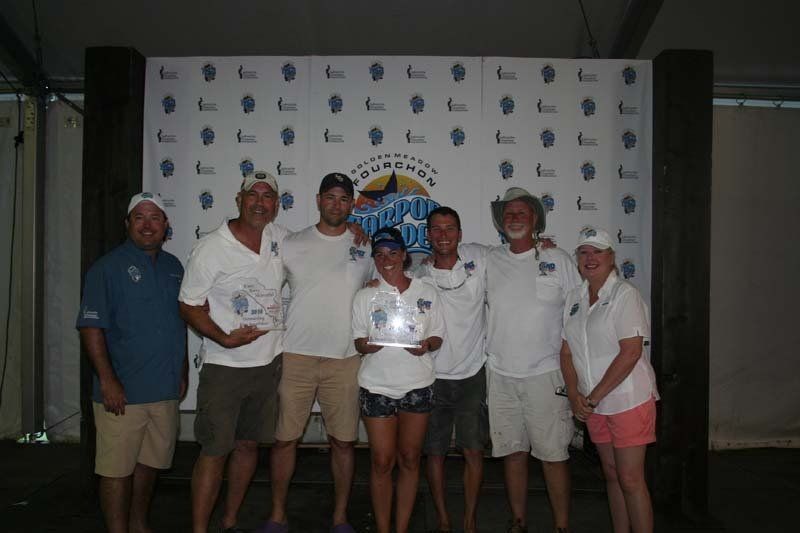 A group of people posing for a picture in front of a wall that says triumph