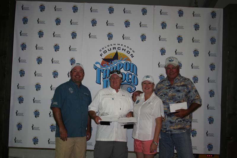 A group of people standing in front of a wall with the word tourchon on it
