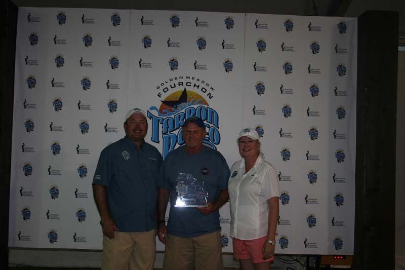Three people standing in front of a wall that says triumph