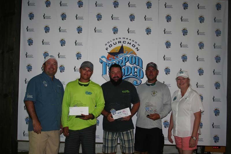 A group of people standing in front of a wall that says fourchon